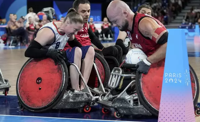 Sarah Adam of the United States, left, blocks Zachary Madel of Canada during the 2024 Paralympics Wheelchair Rugby match United States against Canada at the Champs Mars Arena Thursday, Aug. 29, 2024, in Paris, France. (AP Photo/Michel Euler)