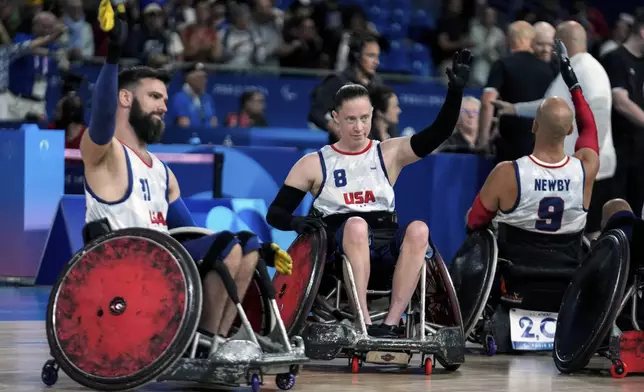 Clayton Brackets, left, and Sarah Adam from the United States acknowledge applauses after they defeated Canada 51-48 during the 2024 Paralympics Wheelchair Rugby match United States against Canada at the Champs Mars Arena Thursday, Aug. 29, 2024, in Paris, France. (AP Photo/Michel Euler)