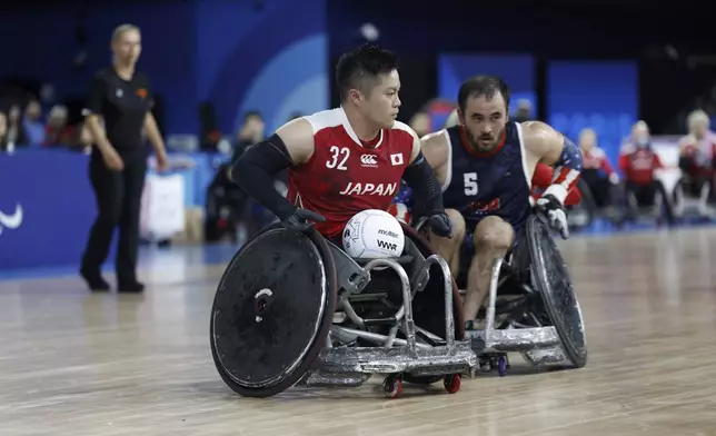 Japan's Katsuya Hashimoto, left, looks to score during the U.S. vs Japan preliminary match of wheelchair rugby, at the Paralympic Games in Paris, Friday, Aug. 30, 2024. Japan won 45-42. (AP Photo/Avni Trivedi)