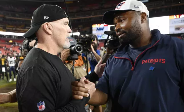 Washington Commanders head coach Dan Quinn, left, greets New England Patriots head coach Jerod Mayo after a preseason NFL football game, Sunday, Aug. 25, 2024, in Landover, Md. (AP Photo/Nick Wass)