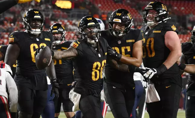 Washington Commanders wide receiver Martavis Bryant, middle left, celebrates with tight end Cole Turner, middle right, and teammates after scoring against the New England Patriots during the second half of a preseason NFL football game, Sunday, Aug. 25, 2024, in Landover, Md. (AP Photo/Nick Wass)