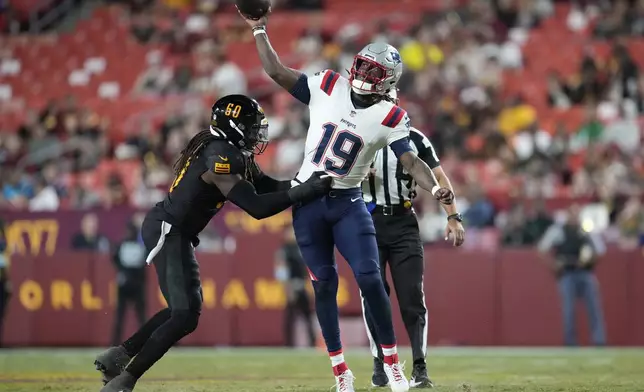 New England Patriots quarterback Joe Milton III (19) passes as Washington Commanders defensive end Andre Jones Jr. (50) applies pressure during the second half of a preseason NFL football game, Sunday, Aug. 25, 2024, in Landover, Md. (AP Photo/George Walker IV)