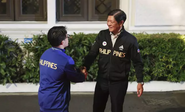 Philippine President Ferdinand Marcos Jr., right, meets Olympic double gold medalist in gymnastics, Carlos Yulo during a welcome ceremony at the Malcañang presidential palace in Manila, Philippines on Tuesday, Aug. 13, 2024. (AP Photo/Basilio Sepe, Pool)