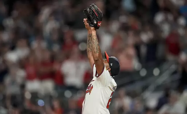 Atlanta Braves reliever Raisel Iglesias (26) celebrates the last stike after the nineth inning of a baseball game against the Philadelphia Phillies, Thursday, Aug. 22, 2024, in Atlanta. (AP Photo/Mike Stewart)