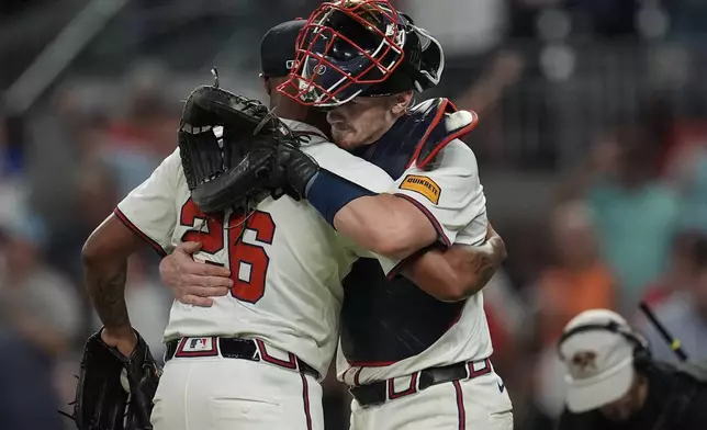 Atlanta Braves reliever Raisel Iglesias (26) celebrates the last stike with Atlanta Braves catcher Sean Murphy (12) after the nineth inning of a baseball game against the Philadelphia Phillies, Thursday, Aug. 22, 2024, in Atlanta. (AP Photo/Mike Stewart)