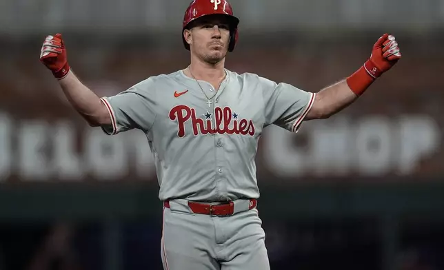 Philadelphia Phillies catcher J.T. Realmuto (10) celebrates hitting an RBI-double in the seventh inning of a baseball game against the Atlanta Braves, Thursday, Aug. 22, 2024, in Atlanta. (AP Photo/Mike Stewart)