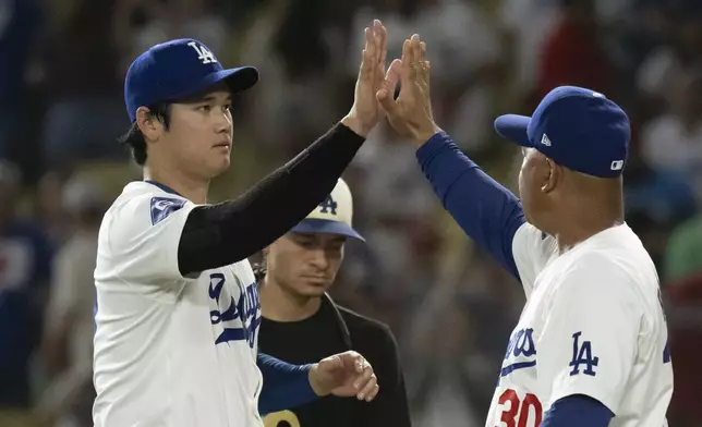 Los Angeles Dodgers' Shohei Ohtani, left and manager Dave Roberts celebrate the team's 5-3 win over the Philadelphia Phillies in a baseball game in Los Angeles, Monday, Aug. 5, 2024. (AP Photo/Kyusung Gong)