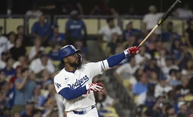 Los Angeles Dodgers' Teoscar Hernández watches his solo home run during the eighth inning of a baseball game against the Philadelphia Phillies in Los Angeles, Tuesday, Aug. 6, 2024. (AP Photo/Kyusung Gong)