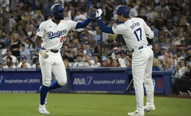 Los Angeles Dodgers outfielder Jason Heyward (23) celebrates after scoring on an RBI double by Andy Pages with Shohei Ohtani (17) during the third inning of a baseball game against the Philadelphia Phillies in Los Angeles, Monday, Aug. 5, 2024. (AP Photo/Kyusung Gong)