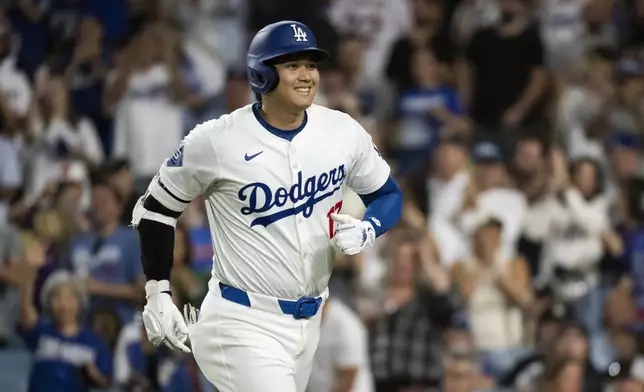 Los Angeles Dodgers' Shohei Ohtani jogs back to the dugout after hitting a solo home run during the eighth inning of a baseball game against the Philadelphia Phillies in Los Angeles, Monday, Aug. 5, 2024. (AP Photo/Kyusung Gong)