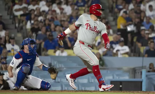 Philadelphia Phillies' Kyle Schwarber hits an RBI single during the fifth inning of a baseball game against the Los Angeles Dodgers in Los Angeles, Tuesday, Aug. 6, 2024. (AP Photo/Kyusung Gong)