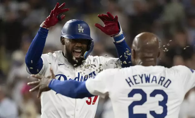 Los Angeles Dodgers' Teoscar Hernández is hit with sunflower seeds by Jason Heyward (23) after hitting a two-run home run during the third inning of a baseball game against the Philadelphia Phillies in Los Angeles, Monday, Aug. 5, 2024. (AP Photo/Kyusung Gong)