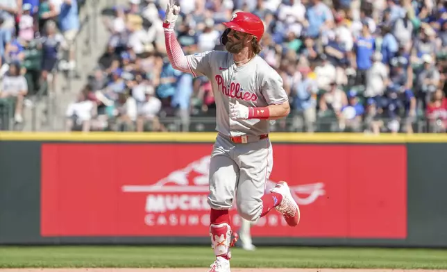 Philadelphia Phillies' Bryce Harper signals to the crowd after hitting a home run during the eighth inning of a baseball game against the Seattle Mariners, Sunday, Aug. 4, 2024, in Seattle. (AP Photo/Liv Lyons)