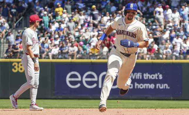 Seattle Mariners' Cal Raleigh rounds second base as he is called out by a catch from Philadelphia Phillies second baseman Bryson Stott during the fourth inning of a baseball game, Sunday, Aug. 4, 2024, in Seattle. (AP Photo/Liv Lyons)