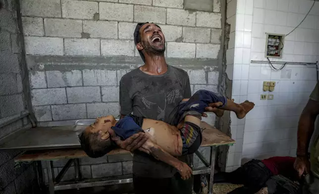 A Palestinian man cries while holding a relative killed in the Israeli bombardment of the Gaza Strip at a hospital morgue in Deir al-Balah, Aug. 28, 2024. (AP Photo/Abdel Kareem Hana)