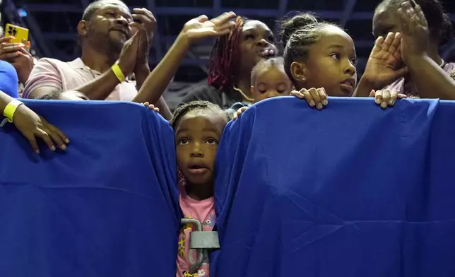 A child looks between crowd barriers watching Vice President Kamala Harris speak at a campaign rally in Savannah, Ga., Aug. 29, 2024. (AP Photo/Jacquelyn Martin)