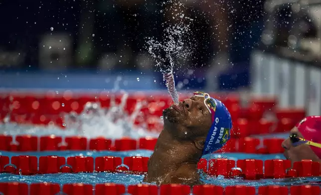 Paralympic athlete Araujo dos Santos, of Brazil, spits water to celebrate his victory in the men's 100-meter backstroke -S2 final, at the 2024 Paralympics, in Paris, Aug. 29, 2024. (AP Photo/Emilio Morenatti)