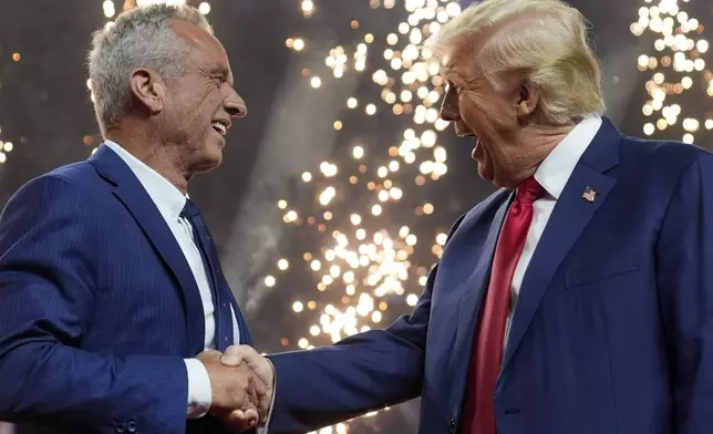 Robert F. Kennedy Jr., who earlier in the day suspended his independent campaign for the White House and endorsed Donald Trump, shakes his hand at a campaign rally in Glendale, Ariz., Aug. 23, 2024. (AP Photo/Evan Vucci)