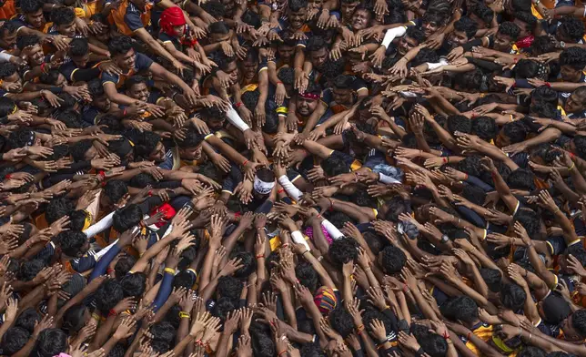 Revelers pay respect before forming human pyramids while celebrating Janmashtami, a festival that marks the birth of the Hindu God Krishna, in Mumbai, India, Aug. 27, 2024.(AP Photo/Rafiq Maqbool)