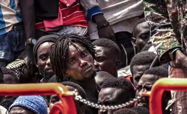 Migrants wait to disembark from a crowded boat after a thirteen-day voyage from the coast of Senegal, at La Estaca port in El Hierro, Spain, Aug. 26, 2024. (AP Photo/Maria Ximena)