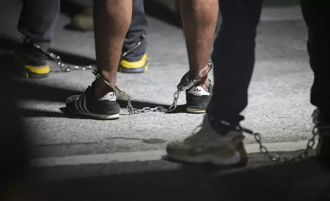 Shackled migrants line up as they board a flight to be deported to Colombia, at the Albrook airport in Panama City, Aug. 24, 2024. (AP Photo/Matias Delacroix)