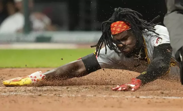 Pittsburgh Pirates' Oneil Cruz slides safely across home plate to score in the fifth inning of a baseball game against the Cleveland Guardians, Friday, Aug. 30, 2024, in Cleveland. (AP Photo/Sue Ogrocki)