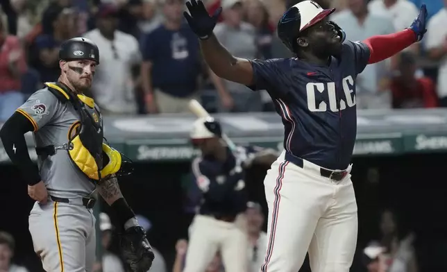 Cleveland Guardians' Jhonkensy Noel, right, celebrates in front of Pittsburgh Pirates catcher Yasmani Grandal, left, after hitting a home run in the fifth inning of a baseball game, Friday, Aug. 30, 2024, in Cleveland. (AP Photo/Sue Ogrocki)