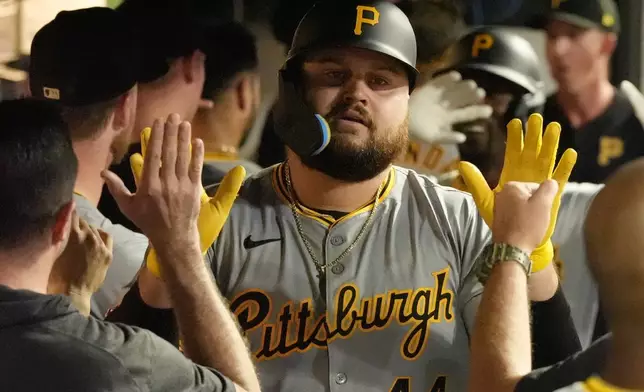 Pittsburgh Pirates' Rowdy Tellez is congratulated in the dugout following his home run in the fifth inning of a baseball game against the Cleveland Guardians Friday, Aug. 30, 2024, in Cleveland. (AP Photo/Sue Ogrocki)