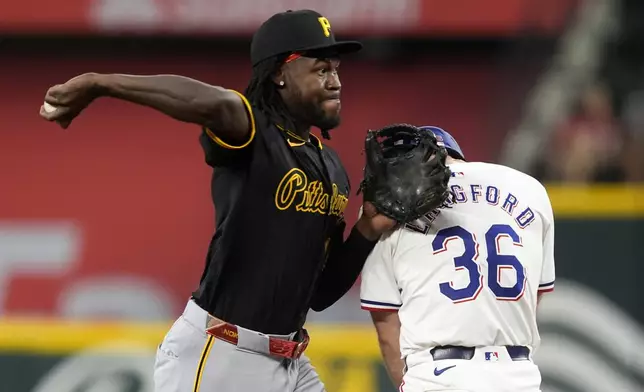 Pittsburgh Pirates shortstop Oneil Cruz throws to first over Texas Rangers' Wyatt Langford (36) to complete a ground out by Travis Jankowski in the second inning of a baseball game, Wednesday, Aug. 21, 2024, in Arlington, Texas. (AP Photo/Tony Gutierrez)