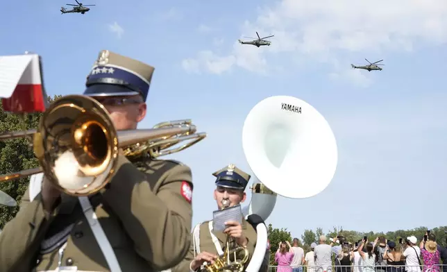 Helicopters fly during a Polish military parade on the occasion of the armed forces day, in Warsaw, Poland, on Thursday, Aug. 15, 2024. (AP Photo/Czarek Sokolowski)