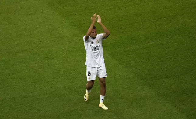 Real Madrid's Kylian Mbappe applauds fans as he takes a walk on the pitch ahead of the UEFA Super Cup Final soccer match between Real Madrid and Atalanta at the Narodowy stadium in Warsaw, Poland, Wednesday, Aug. 14, 2024. (AP Photo/Darko Vojinovic)