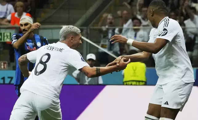 Real Madrid's Federico Valverde, centre, celebrates with Kylian Mbappe after scoring the opening goal during the UEFA Super Cup Final soccer match between Real Madrid and Atalanta at the Narodowy stadium in Warsaw, Poland, Wednesday, Aug. 14, 2024. (AP Photo/Czarek Sokolowski)