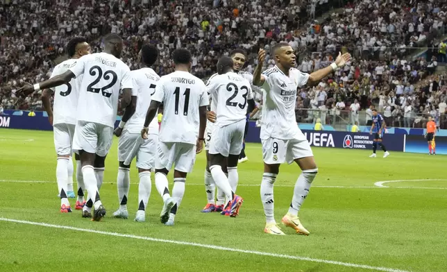 Real Madrid's Kylian Mbappe, right, celebrates after scoring his side's second goal during the UEFA Super Cup Final soccer match between Real Madrid and Atalanta at the Narodowy stadium in Warsaw, Poland, Wednesday, Aug. 14, 2024. (AP Photo/Czarek Sokolowski)