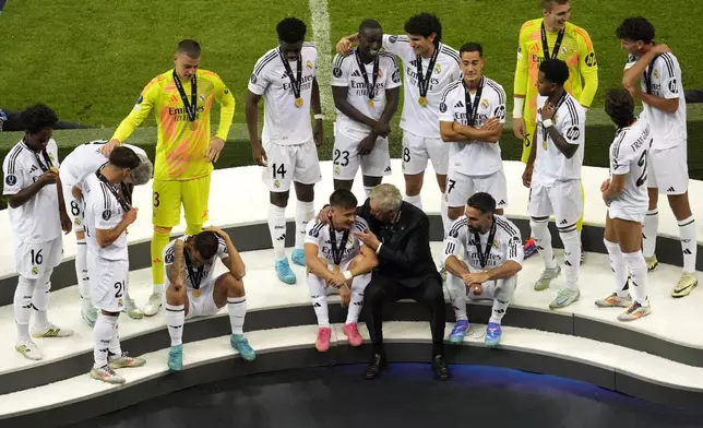 Real Madrid's head coach Carlo Ancelotti, center, speaks with his player Arda Guler at the end of the UEFA Super Cup Final soccer match between Real Madrid and Atalanta at the Narodowy stadium in Warsaw, Poland, Wednesday, Aug. 14, 2024. Real Madrid won 2-0. (AP Photo/Darko Vojinovic)