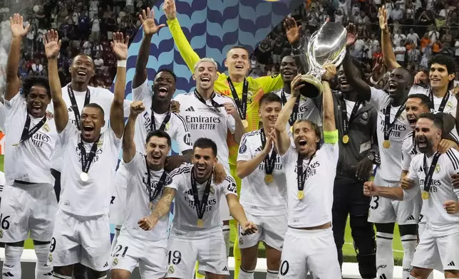 Real Madrid's team members celebrate with the trophy as they won the UEFA Super Cup Final soccer match between Real Madrid and Atalanta at the Narodowy stadium in Warsaw, Poland, Wednesday, Aug. 14, 2024. (AP Photo/Czarek Sokolowski)