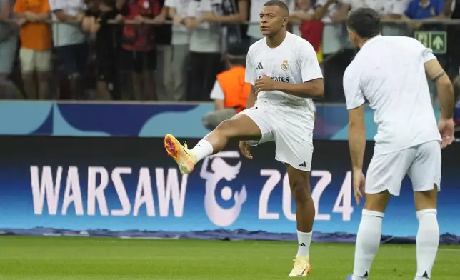 Real Madrid's Kylian Mbappe warms up before the UEFA Super Cup Final soccer match between Real Madrid and Atalanta at the Narodowy stadium in Warsaw, Poland, Wednesday, Aug. 14, 2024. (AP Photo/Czarek Sokolowski)