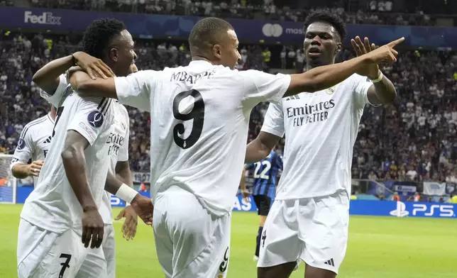 Real Madrid's Kylian Mbappe, centre, celebrates with teammates after scoring his side's second goal during the UEFA Super Cup Final soccer match between Real Madrid and Atalanta at the Narodowy stadium in Warsaw, Poland, Wednesday, Aug. 14, 2024. (AP Photo/Czarek Sokolowski)