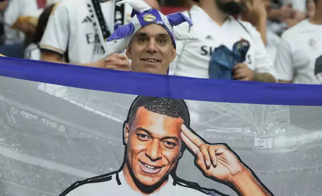 Real Madrid's fan holds a portrait of Kylian Mbappe before the UEFA Super Cup Final soccer match between Real Madrid and Atalanta at the Narodowy stadium in Warsaw, Poland, Wednesday, Aug. 14, 2024. (AP Photo/Czarek Sokolowski)