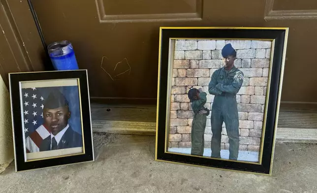 Candles and framed photos of Roger Fortson, a U.S. Air Force senior airman who was fatally shot by a Fla. sheriff's deputy on May 3, 2024, sit on Friday, Aug. 23, in the doorway of the apartment where he was killed in Fort Walton Beach, Fla. (AP Photo/Kate Payne)