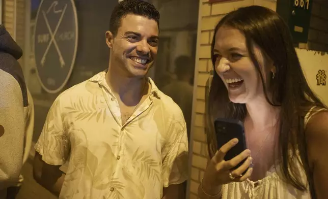 Surf Church pastor, the Rev. Samuel Cianelli, and church member Lydia Fleete laugh outside the church in the suburbs of Porto, Portugal on Sunday, Aug. 18, 2024. (AP Photo/Luis Andres Henao)