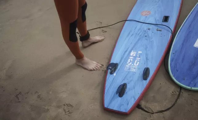 Surf Church pastor, the Rev. Samuel Cianelli, gets ready to surf with members of his congregation in Matosinhos beach in the suburbs of Porto, Portugal on Sunday, Aug. 18, 2024. (AP Photo/Luis Andres Henao)