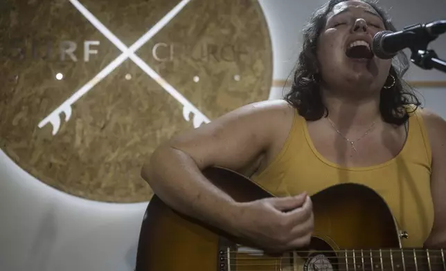 Surf Church member Annalise Hunnicut sings during a worship service at the church in Porto, Portugal on Sunday, Aug. 18, 2024. (AP Photo/Luis Andres Henao)