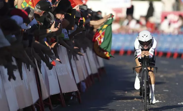 Joao Almeida, of Portugal, rides past cheering fans during the first stage of the tour of Spain, La Vuelta, cycling race, an individual time trial with start in Lisbon and finish in Oeiras, Portugal, Saturday, Aug. 17, 2024. (AP Photo/Pedro Rocha)