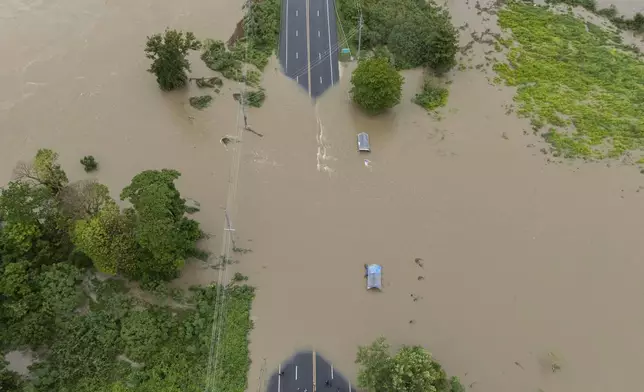 La Plata river floods a road after Tropical Storm Ernesto passed through Toa Baja, Puerto Rico, Wednesday, Aug. 14, 2024. (AP Photo/Alejandro Granadillo)