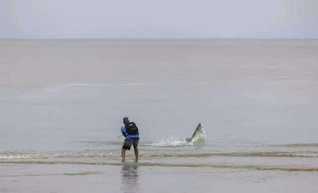 A man fishes after Tropical Storm Ernesto passed through Rio Grande, Puerto Rico, Wednesday, Aug. 14, 2024. (AP Photo/Alejandro Granadillo)