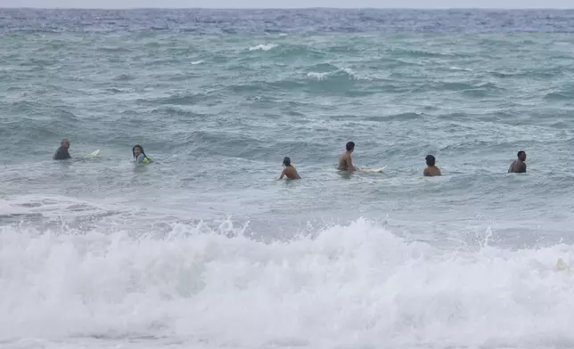 Surfers wait for a wave before the passage of Tropical Storm Ernesto at La Pared beach in Luquillo, Puerto Rico, Tuesday, Aug. 13, 2024. (AP Photo/Alejandro Granadillo)