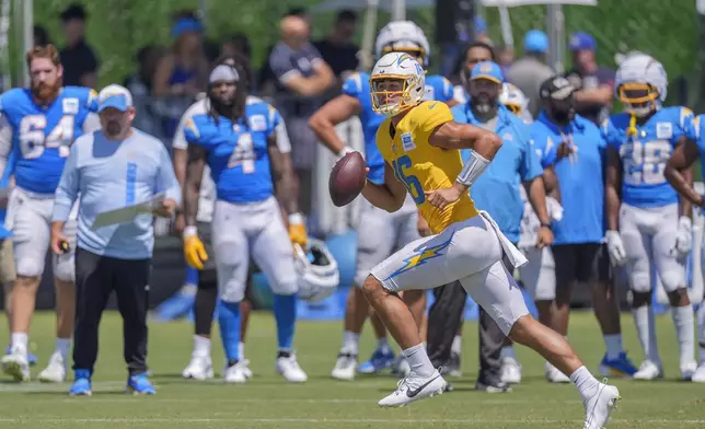 Los Angeles Chargers quarterback Casey Bauman runs with the ball during NFL football practice at The Bolt in El Segundo, Calif., on Sunday, August 4, 2024. The Rams and Chargers are having joint practices. (AP Photo/Damian Dovarganes)