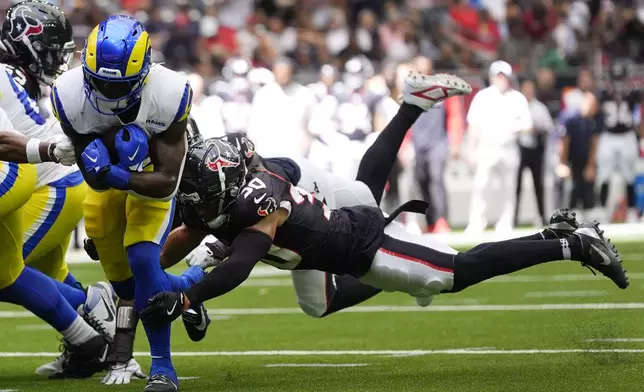 Los Angeles Rams running back Zach Evans, left, runs from Houston Texans cornerback Myles Bryant (30) during a 4-yard touchdown run in the first half of a preseason NFL football game, Saturday, Aug. 24, 2024, in Houston. (AP Photo/Eric Gay)