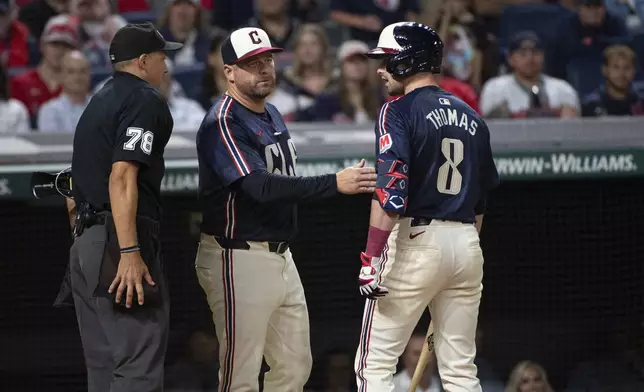 Cleveland Guardians manager Stephen Vogt, center, steps between Lane Thomas (8) and umpire Adam Hamari (78) after Thomas was called out on strikes during the eighth inning of a baseball game against the Texas Rangers in Cleveland, Friday, Aug. 23, 2024. (AP Photo/Phil Long)