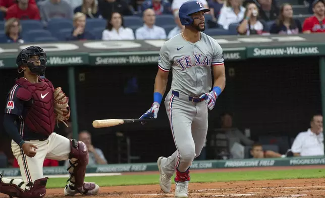 Texas Rangers' Leody Taveras, right, watches his two-run single off Cleveland Guardians starting pitcher Tanner Bibee with Guardians catcher Bo Naylor, left, during the second inning of a baseball game in Cleveland, Friday, Aug. 23, 2024. (AP Photo/Phil Long)